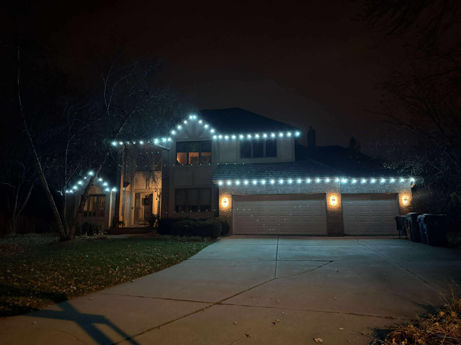Home with bright white permanent roofline lighting at night