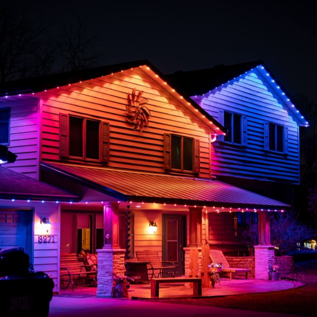Home with warm and blue permanent lights along roofline and porch