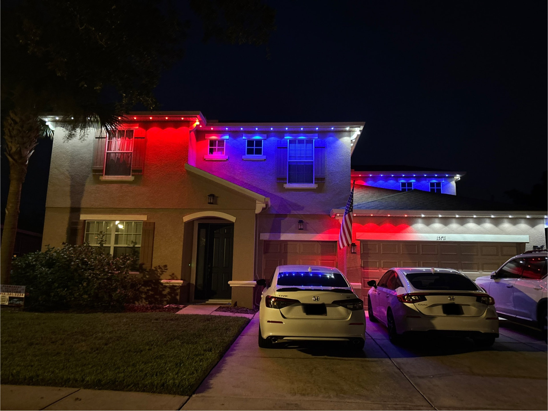 Two-story home with red, white and blue permanent roofline lights