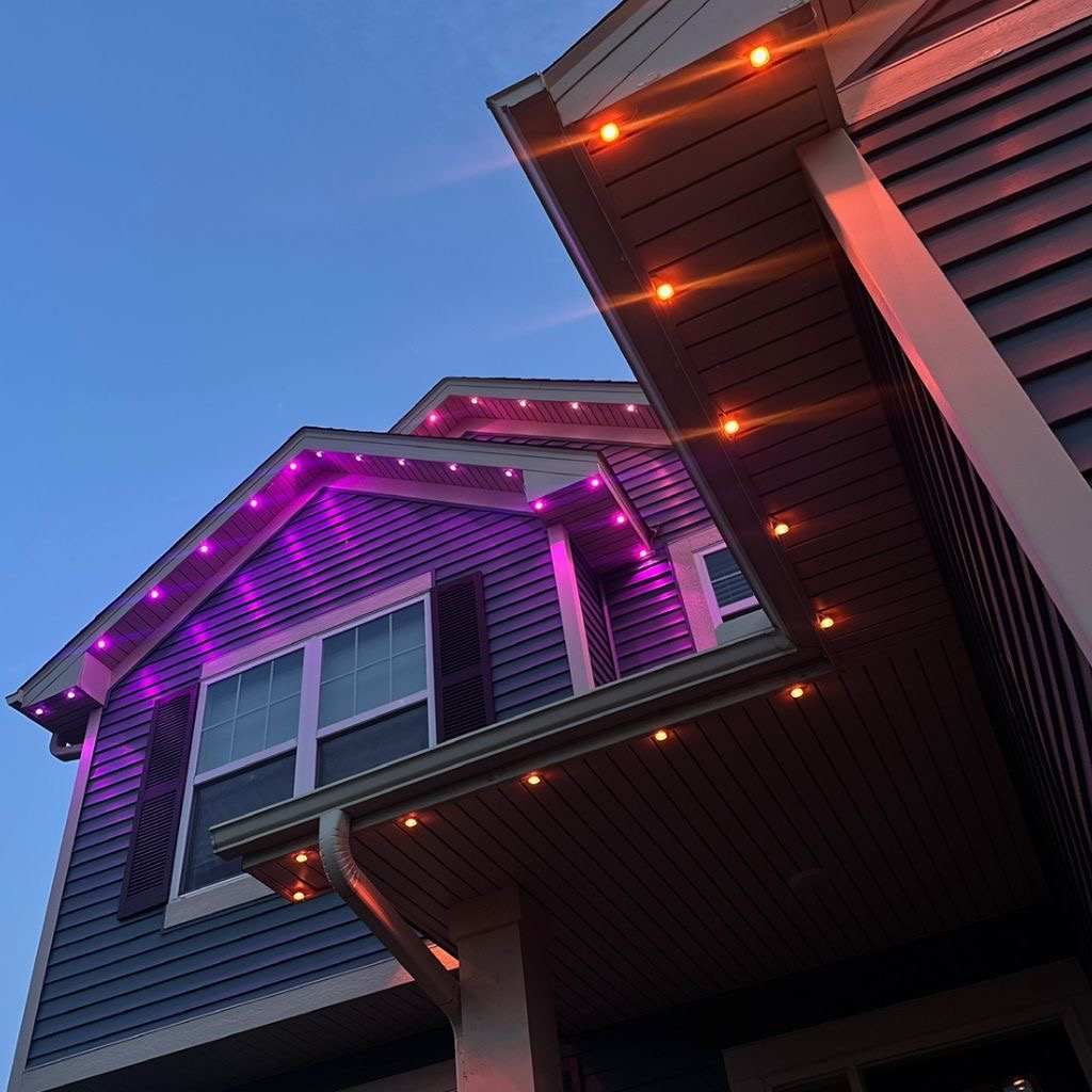 Close-up of purple and orange permanent eave lights at dusk
